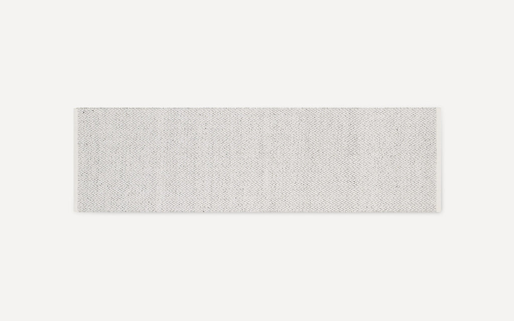 Off-white rectangular woven rug runner with subtle zigzag pattern and frayed ends, displayed on white background.