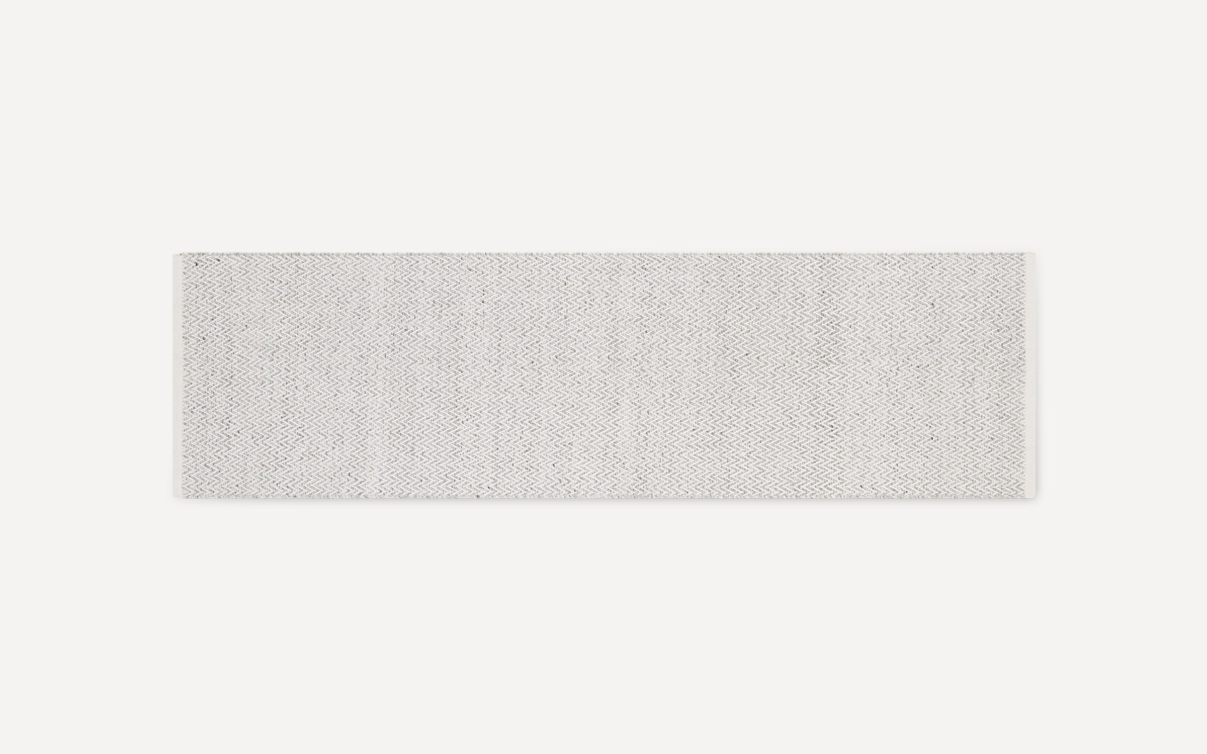 Off-white rectangular woven rug runner with subtle zigzag pattern and frayed ends, displayed on white background.