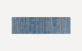 Blue rectangular runner rug with vertical white dotted stripes and irregular block patterns on a light background.