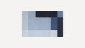 Rectangular rug with a geometric pattern in various shades of blue, including light, medium, and dark tones.