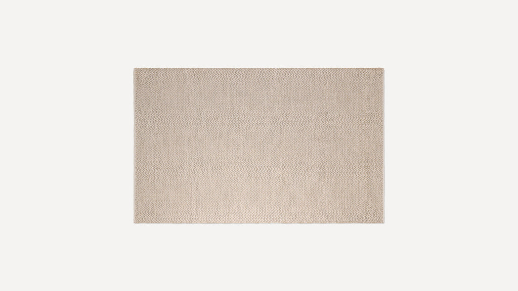 Beige rectangular woven rug with subtle herringbone pattern, flat texture, and clean edges on a white background.