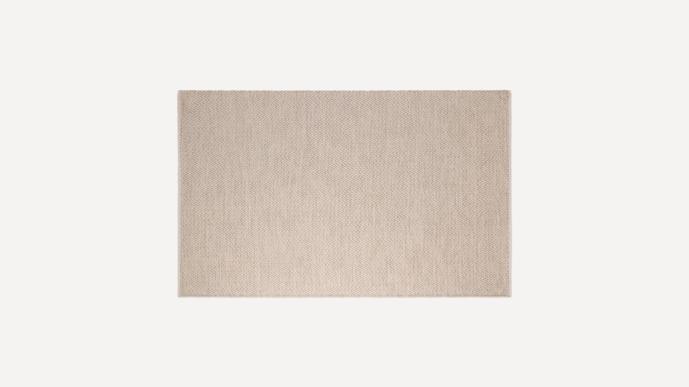 Beige rectangular woven rug with subtle herringbone pattern, flat texture, and clean edges on a white background.