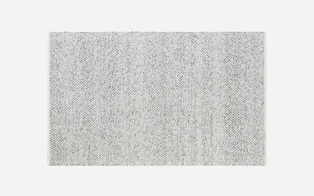 Rectangular grey and white woven area rug with subtle zigzag pattern and a flat texture.