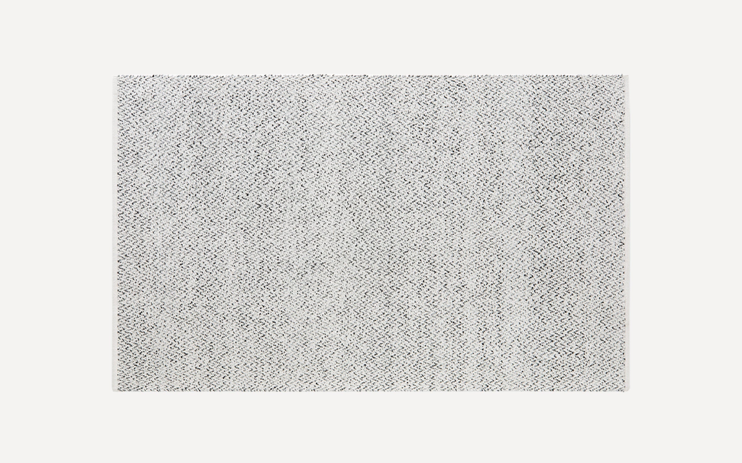 Rectangular grey and white woven area rug with subtle zigzag pattern and a flat texture.