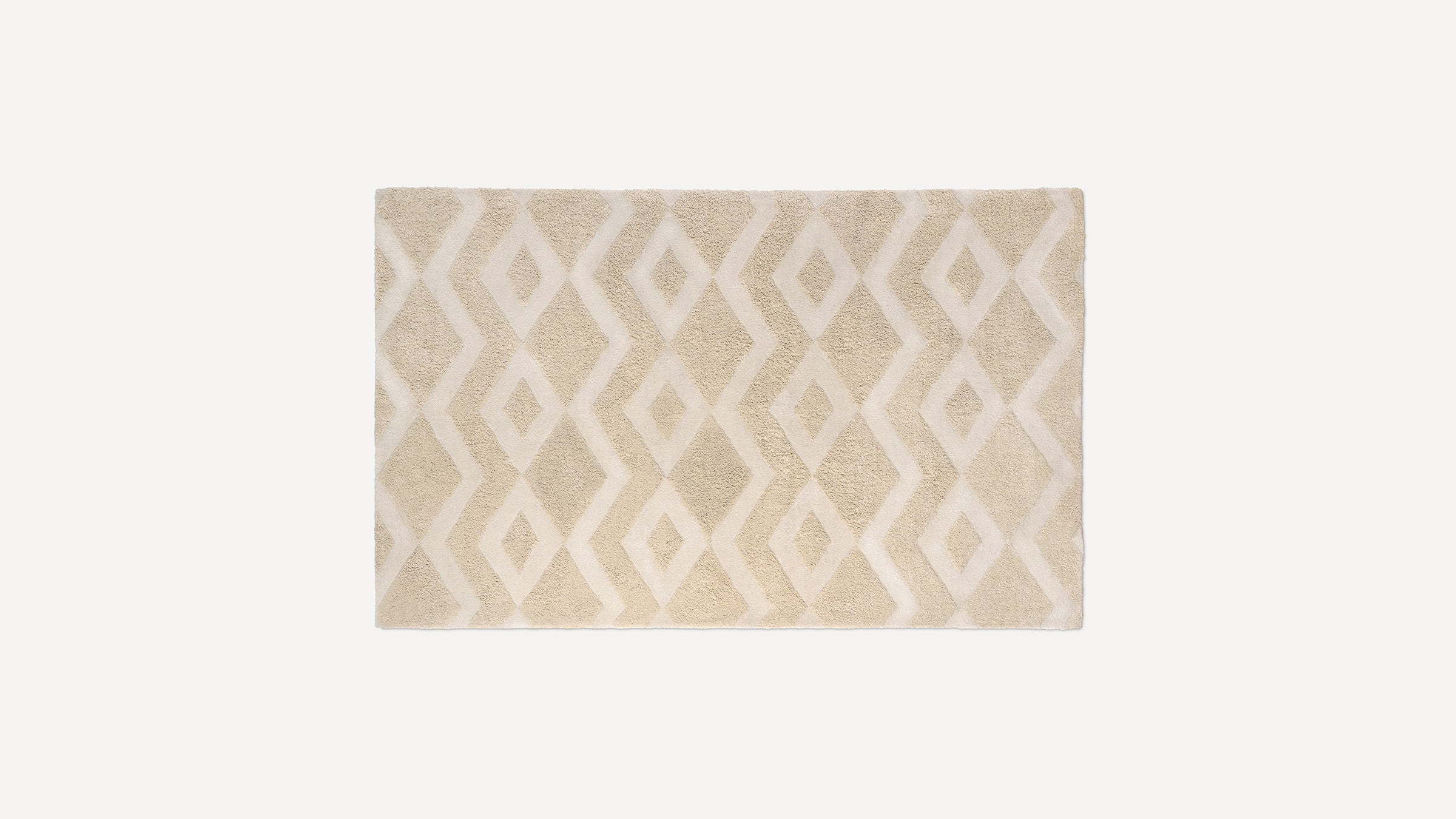 Rectangular beige rug with raised diamond and zigzag pattern, featuring a soft, plush texture.