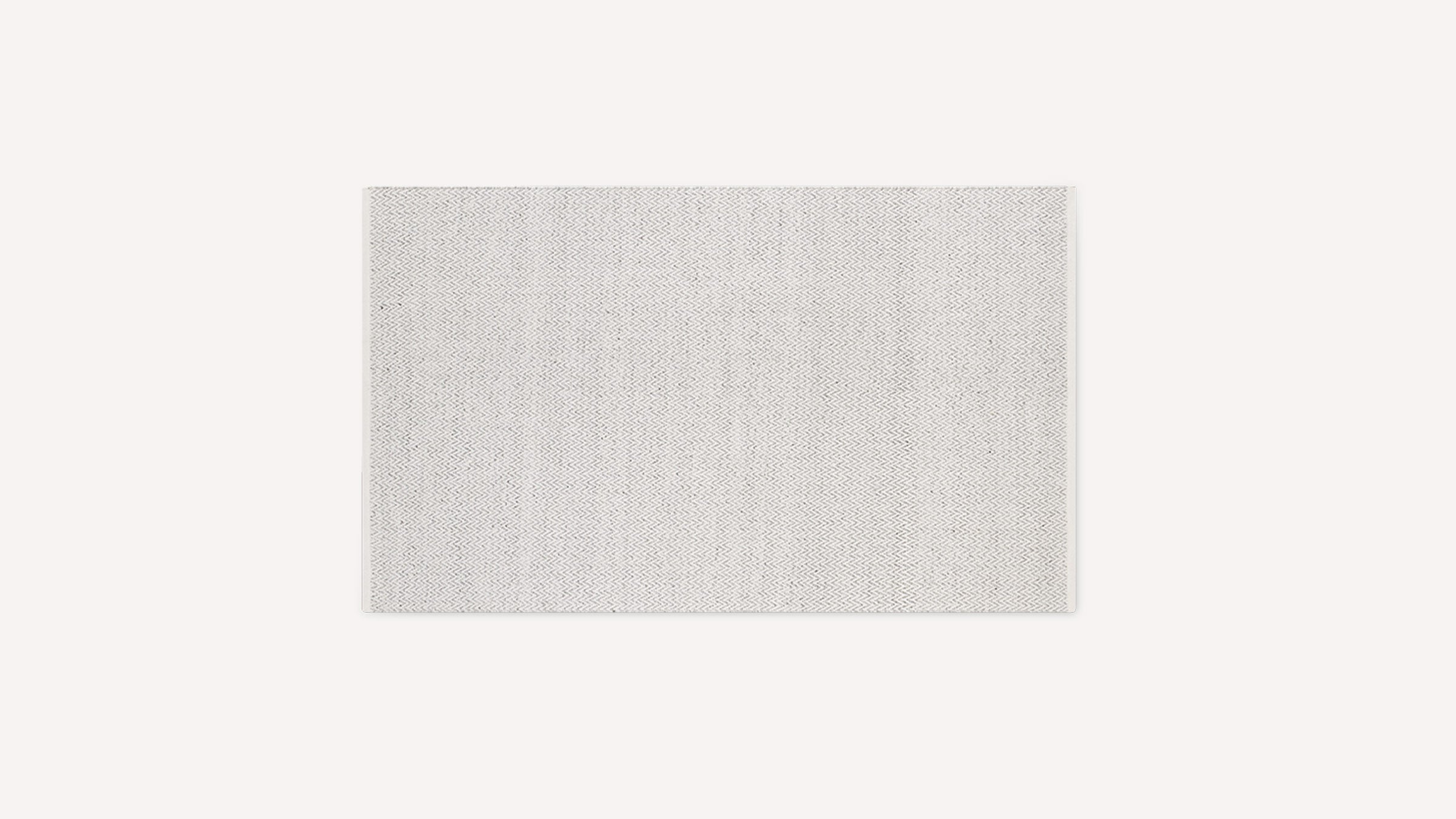 Rectangular light grey floor rug with subtle zigzag pattern and neatly finished edges on a plain white background.