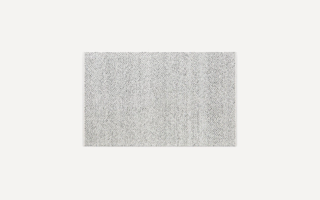 Rectangular light gray area rug with a subtle woven pattern and soft texture, displayed on a white background.