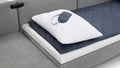 a gray sofa with a pillow and pillow pad on it