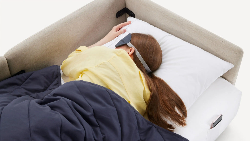 a woman laying on a pillow with a remote control device