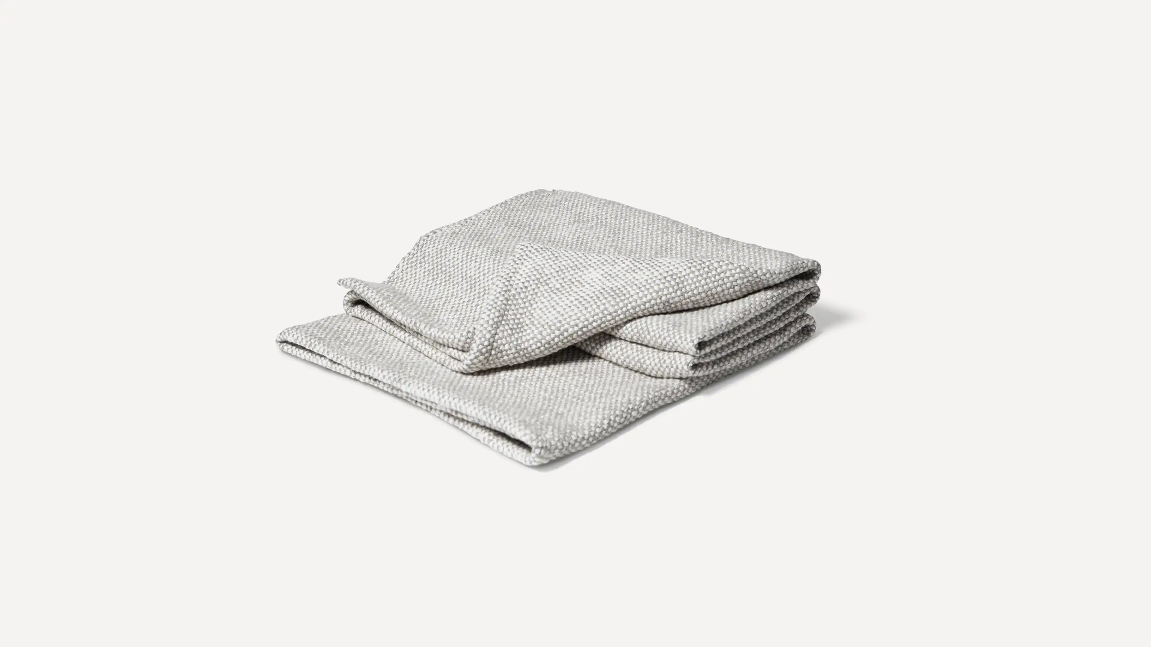 a gray blanket folded on top of a white background