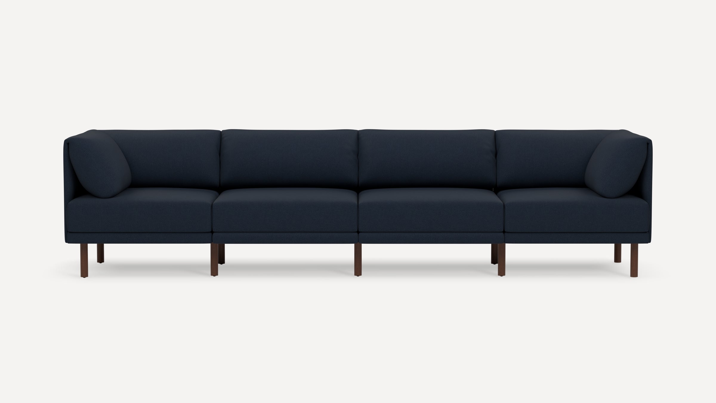 Modern navy blue fabric sectional sofa with wooden legs and four cushions, pictured against plain white background.