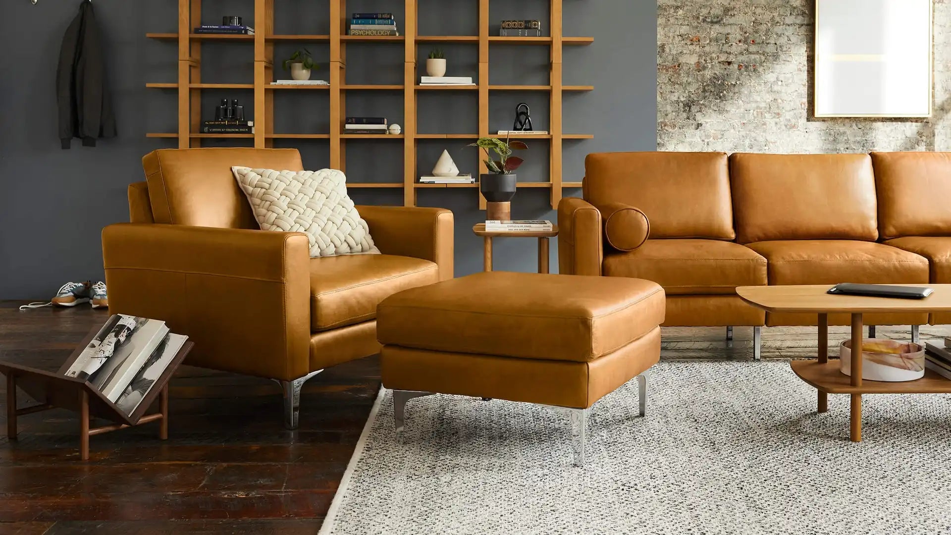 modern living room with brown leather sofas, wooden coffee table, and wooden shelves on the wall