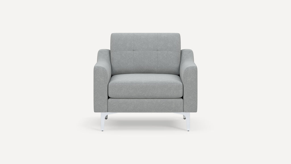 Front view of a modern, light gray fabric armchair with cushioned seat, padded arms, button-tufted backrest, and metal legs.