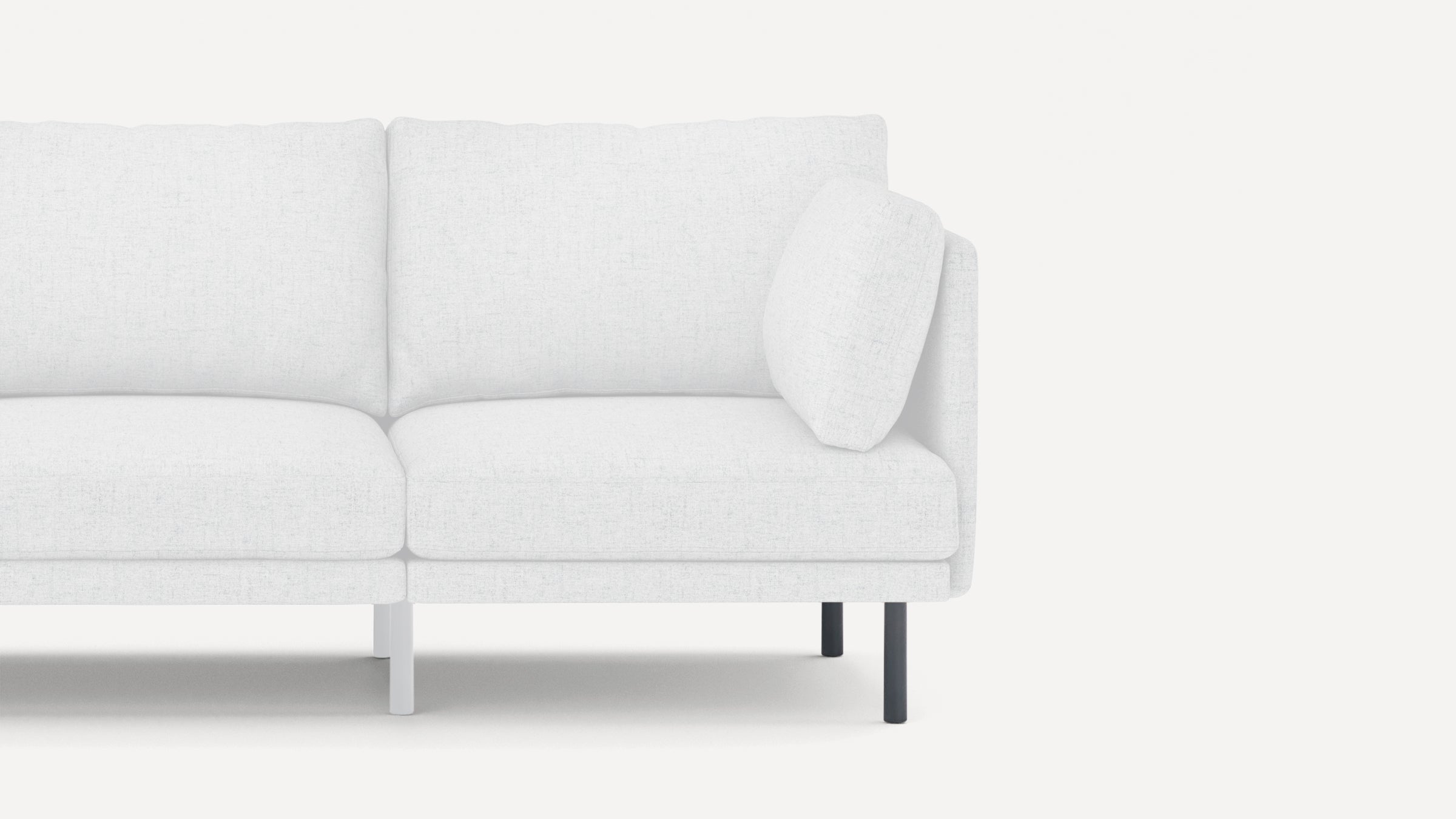Close-up of a modern white fabric sofa section with clean lines and contrasting black and white legs on a white background.