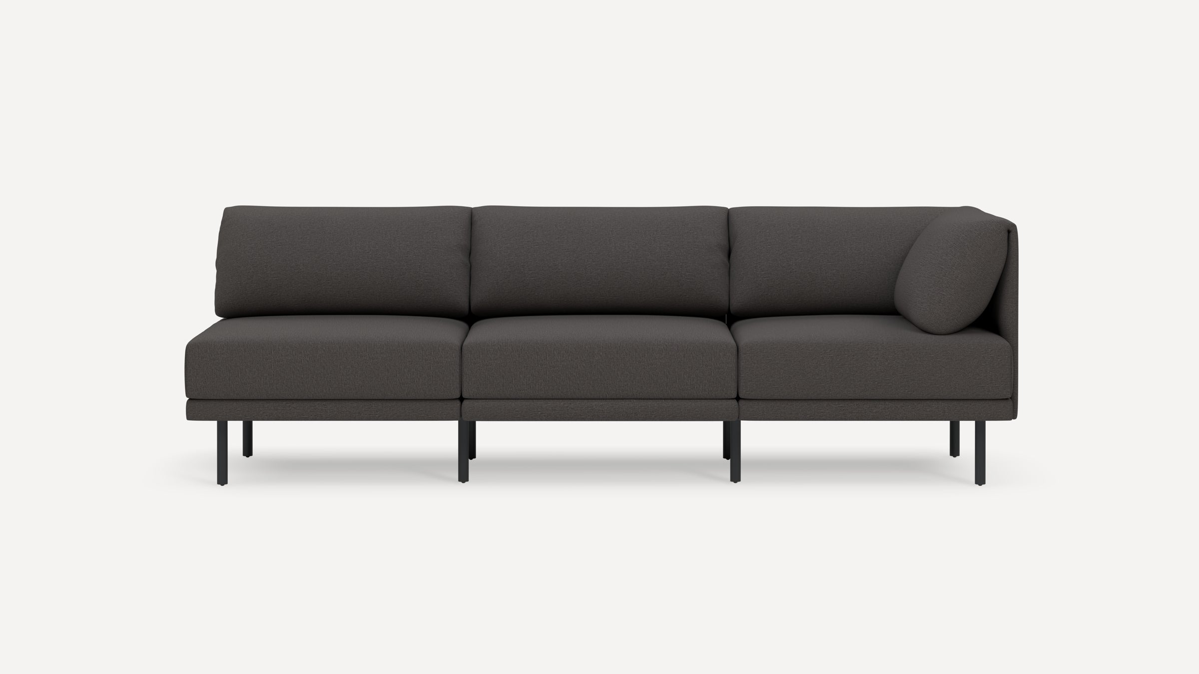 Three-seater modern dark gray sofa with clean lines, slim black metal legs, and a cylindrical cushion on the right armrest.