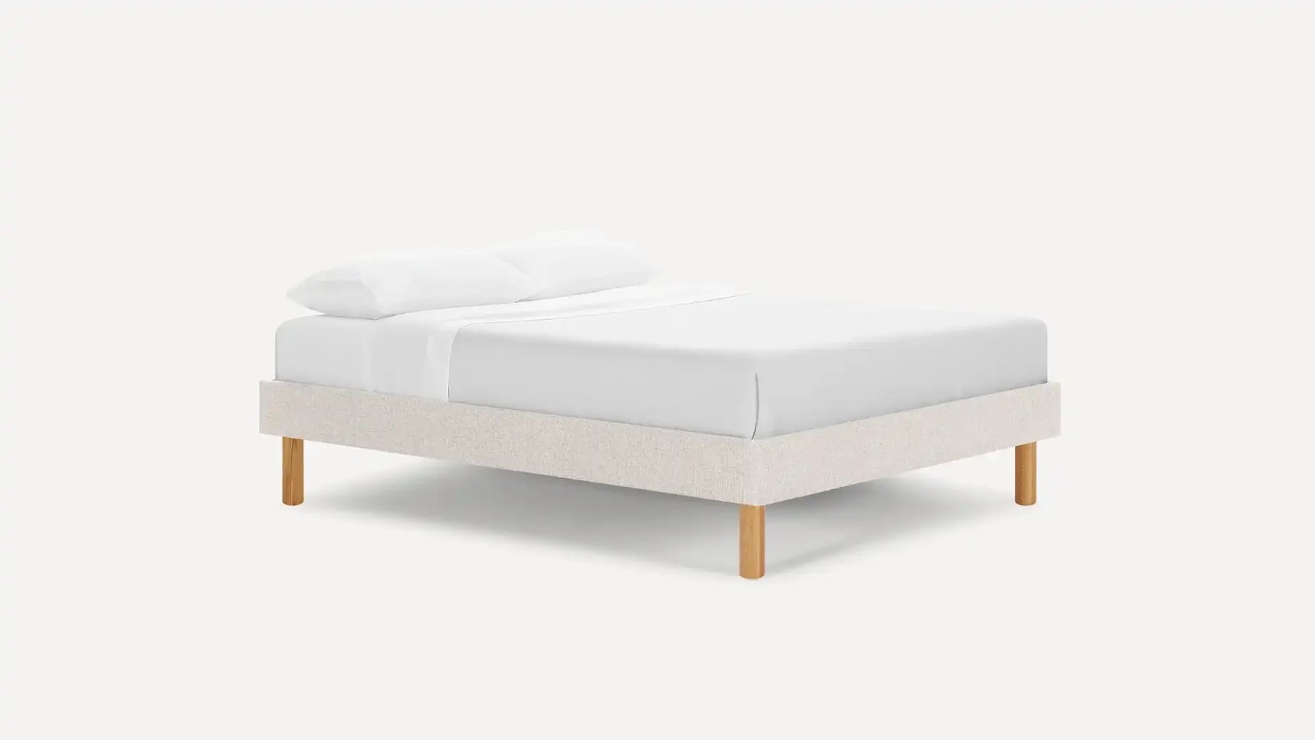 modern upholstered bed with white linen and light wood legs