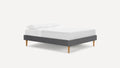 modern upholstered bed with grey upholstered bed frame and white pillows on top of bed