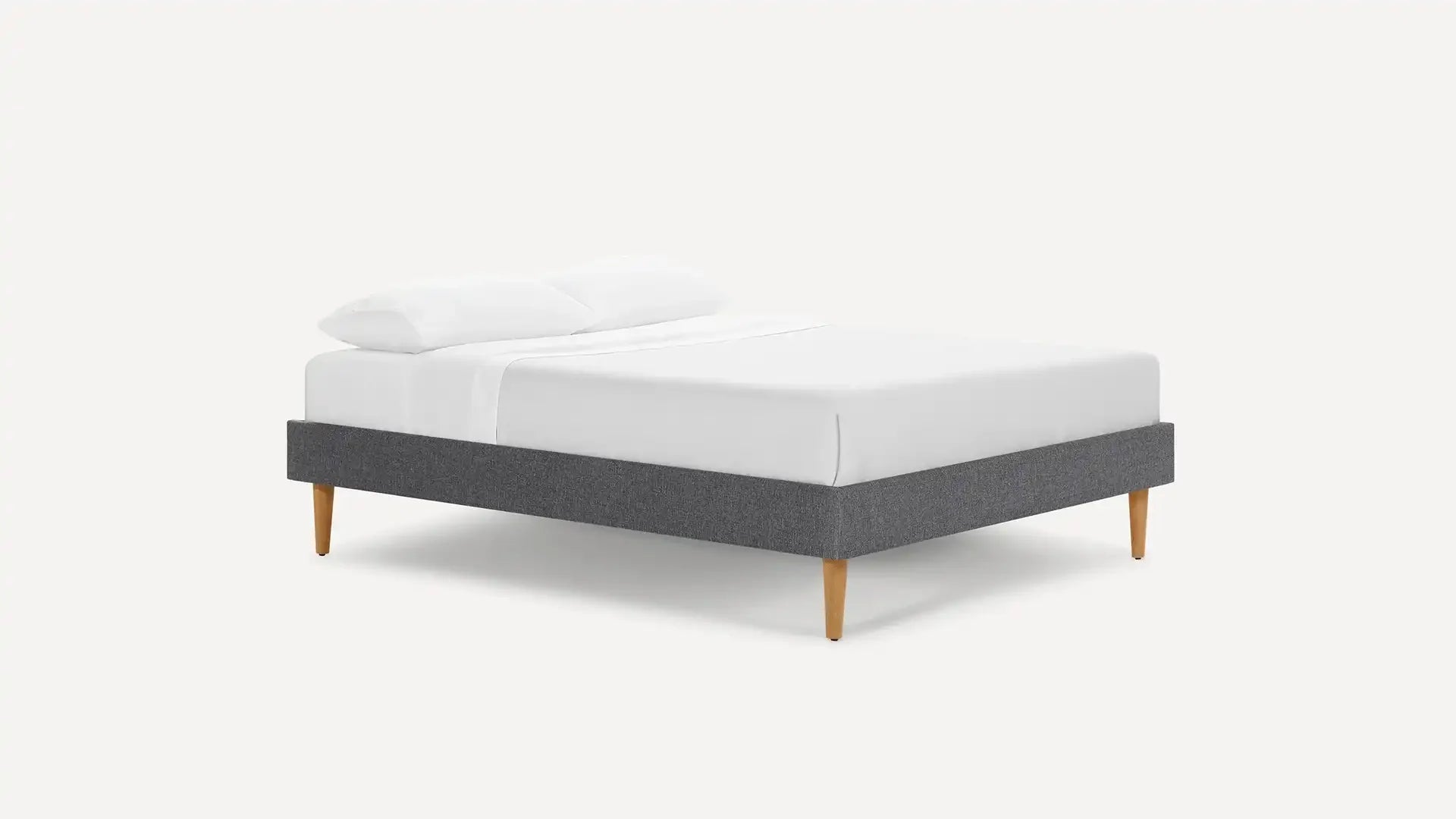 modern upholstered bed with grey upholstered bed frame and white pillows on top of bed