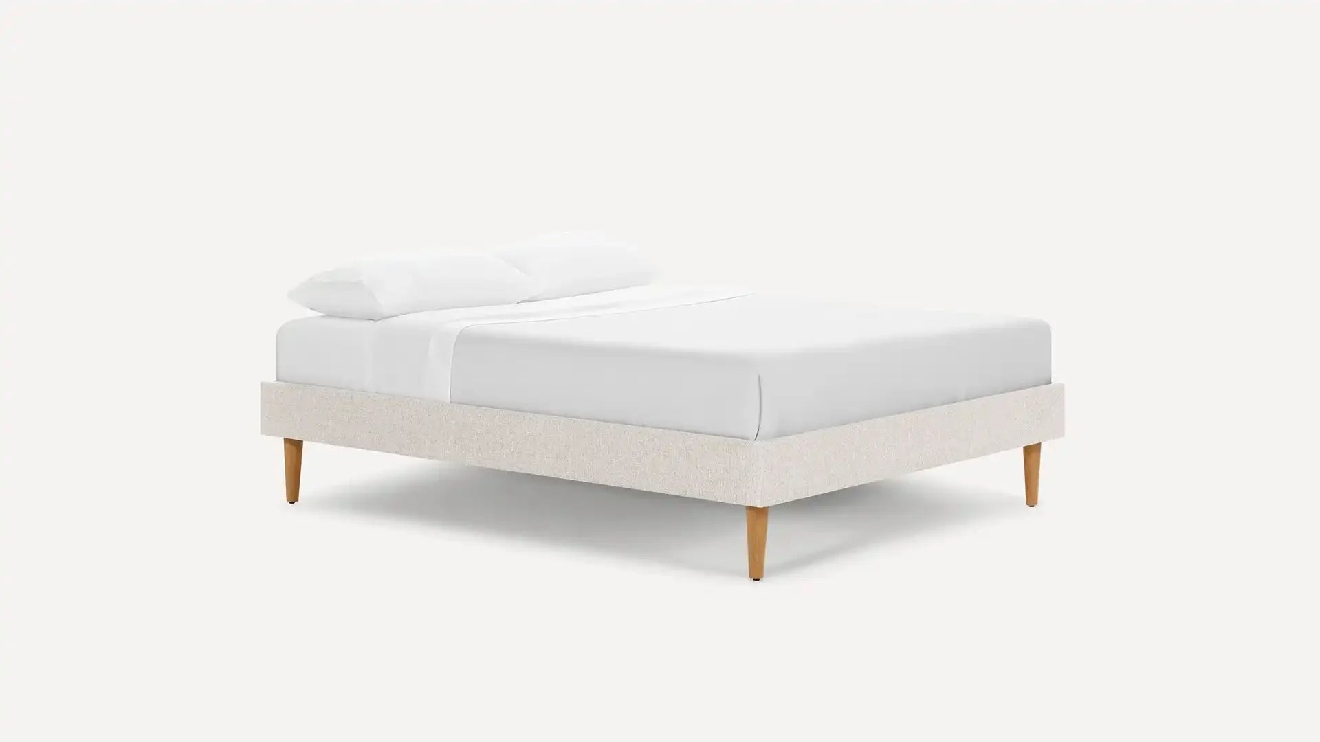 modern upholstered bed with upholstered headboard and white linen upholstered pillow on a white background