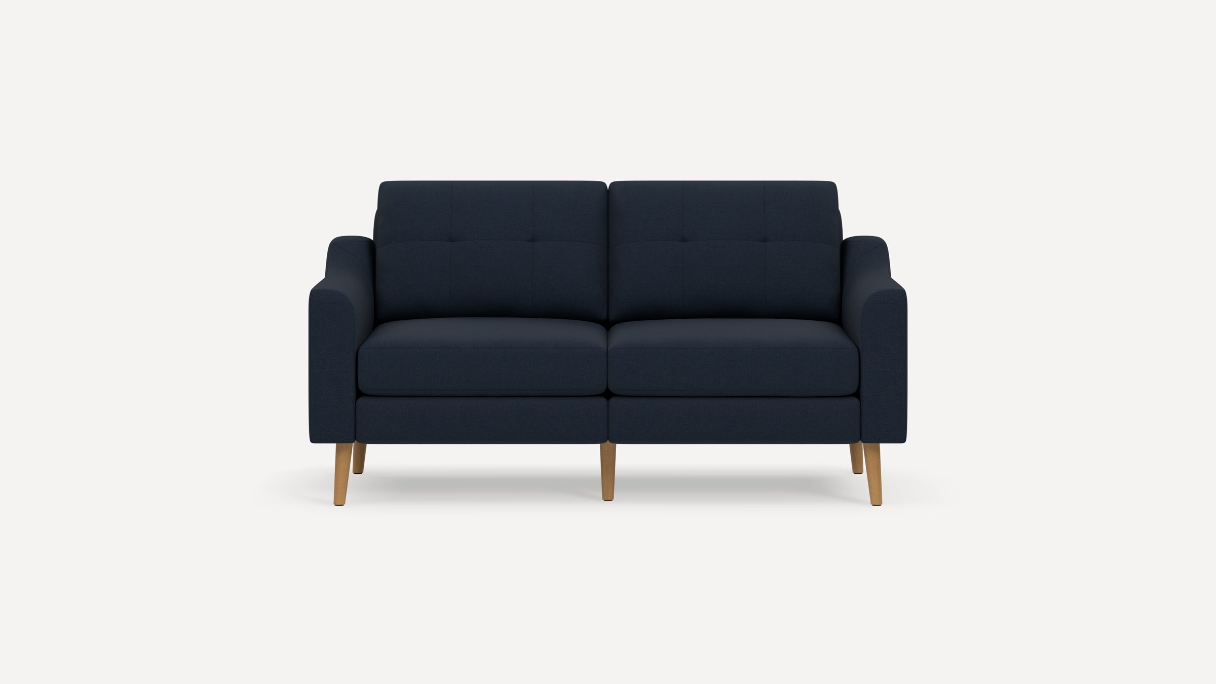 Modern navy blue two-seater sofa with tufted cushions, straight armrests, and light wooden legs on white background.