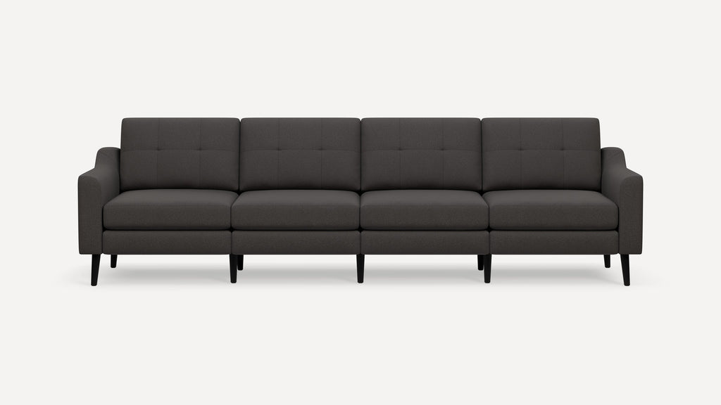 Dark gray modern four-seater sofa with tufted back cushions, slim armrests, and black tapered wooden legs on a white background.