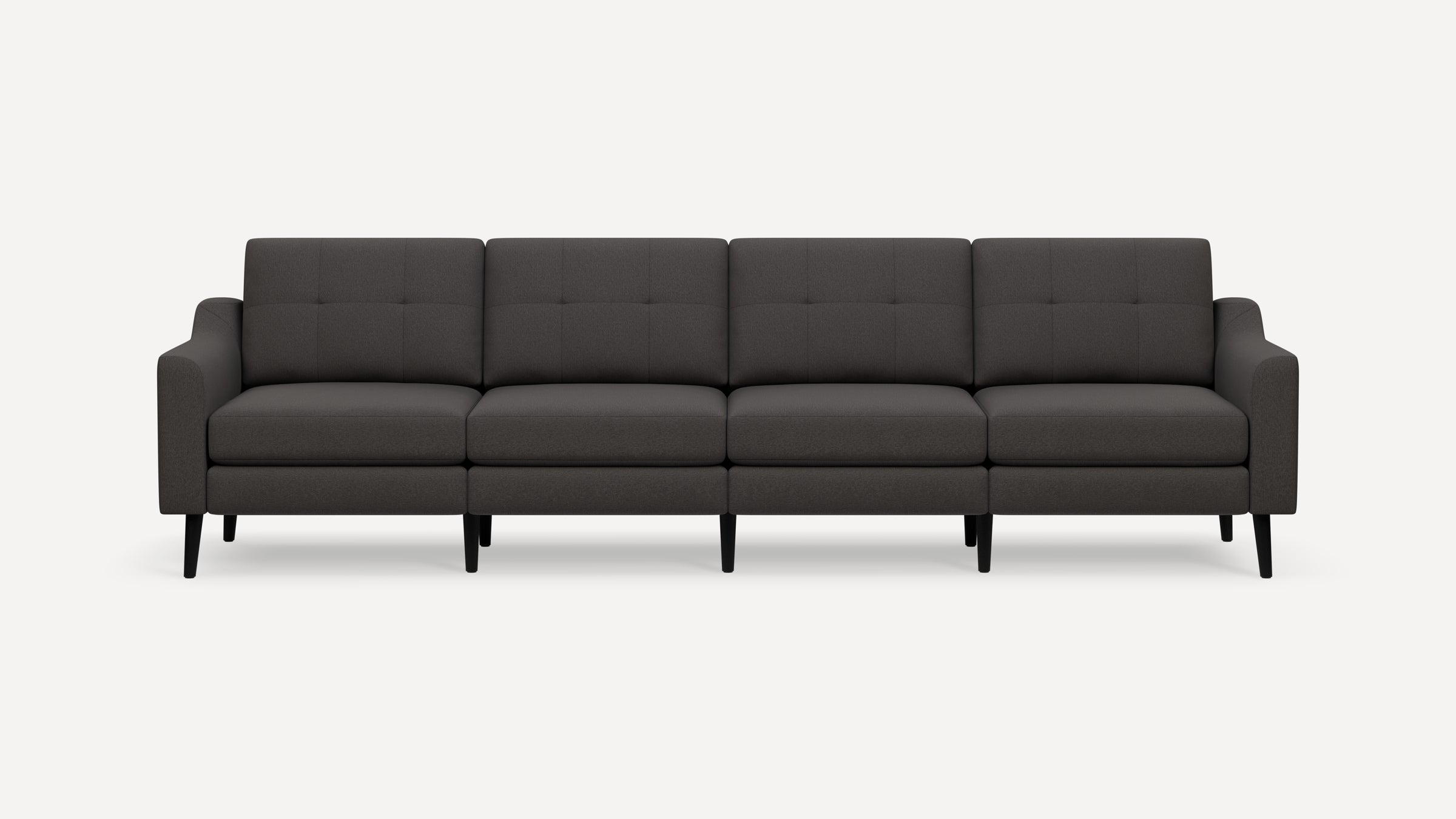Dark gray modern four-seater sofa with tufted back cushions, slim armrests, and black tapered wooden legs on a white background.
