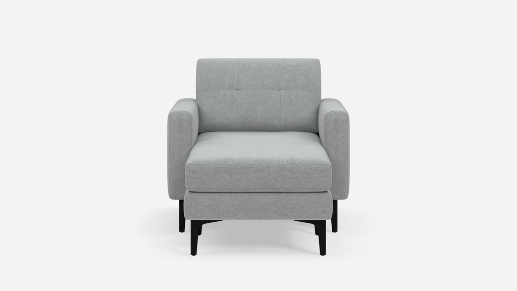 Front view of a modern light gray upholstered armchair with padded armrests and black tapered legs on a white background.