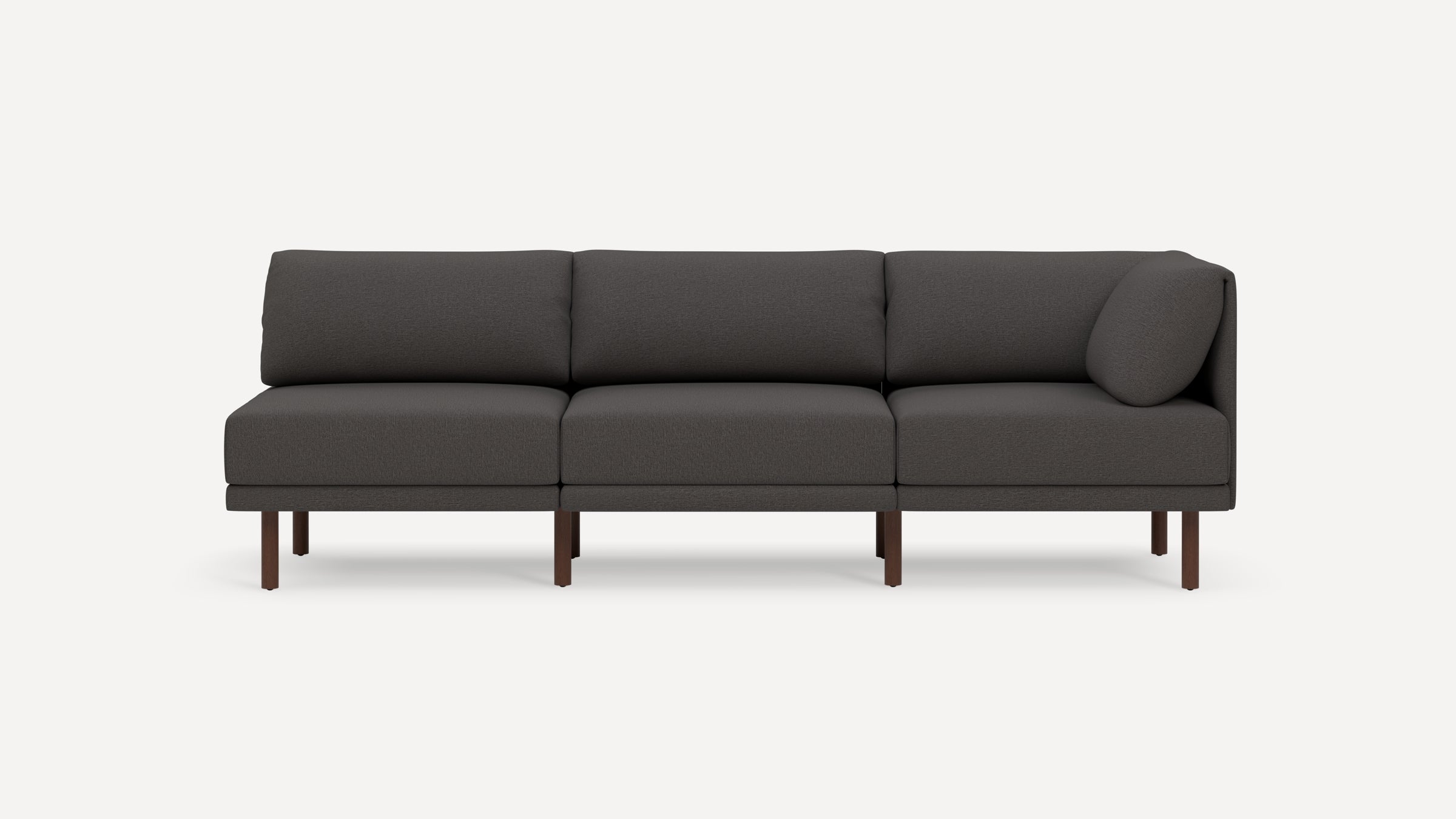 Modern dark gray three-seater sofa with wooden legs and a single cylindrical cushion on the right side.
