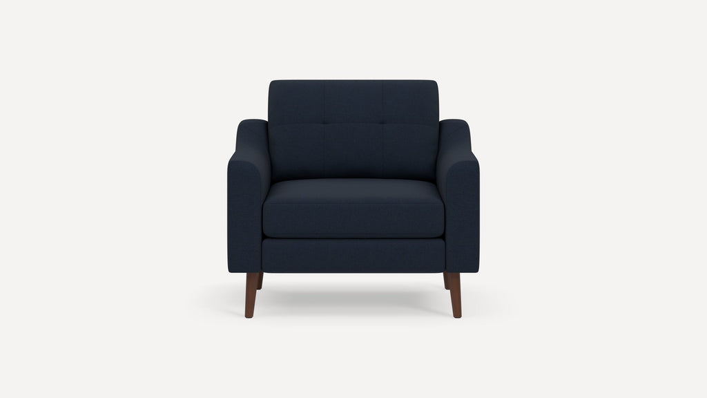 Front view of a modern navy blue upholstered armchair with wooden legs and a cushioned seat and backrest.