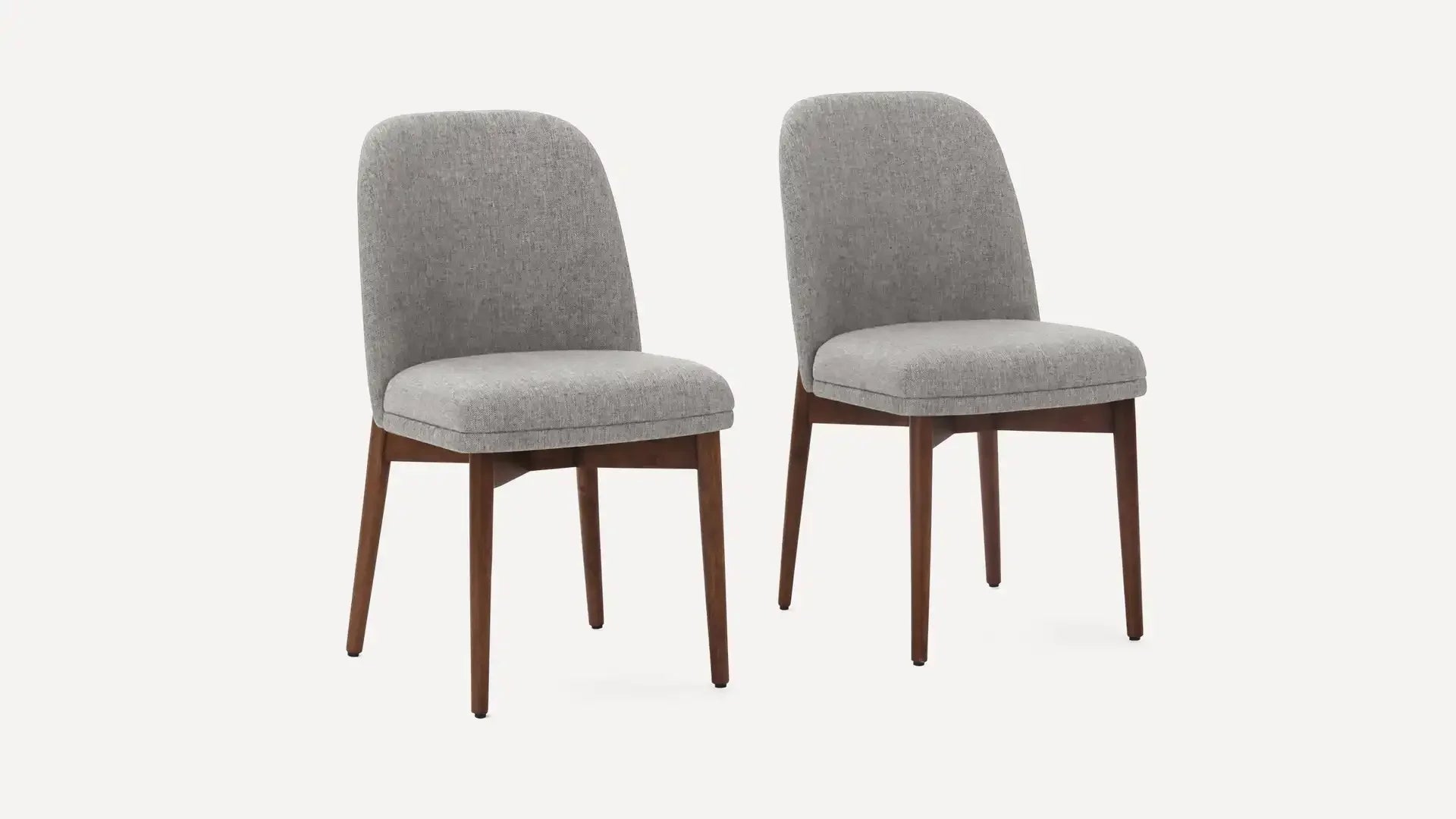 Two modern dining chairs with gray upholstered seats and backs, supported by dark wooden legs.