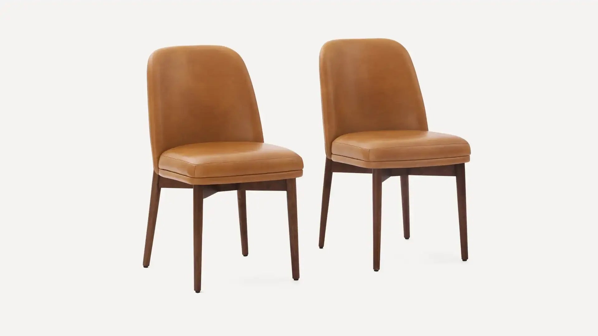 Two modern dining chairs with brown leather upholstery and dark wooden legs against a white background.