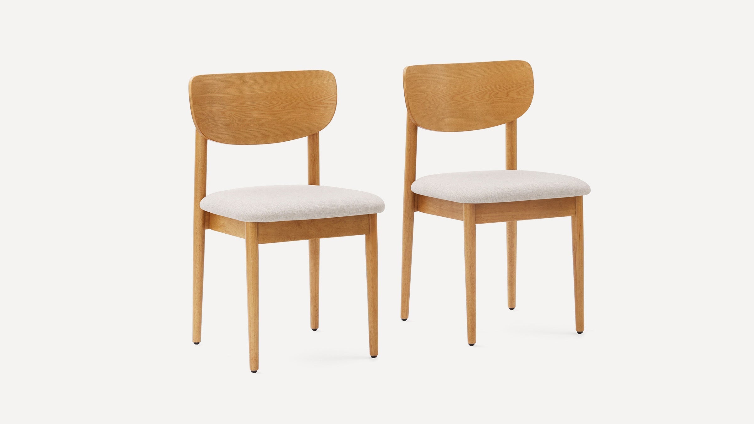 Two wooden dining chairs with light wood frames, curved backs, and white cushioned seats on a white background.