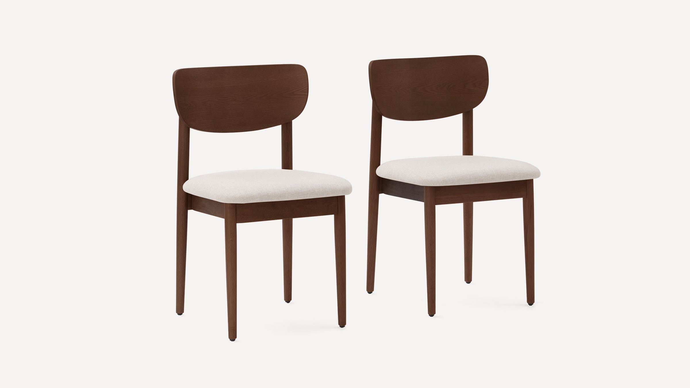Two wooden dining chairs with curved backrests and beige cushioned seats on white background.