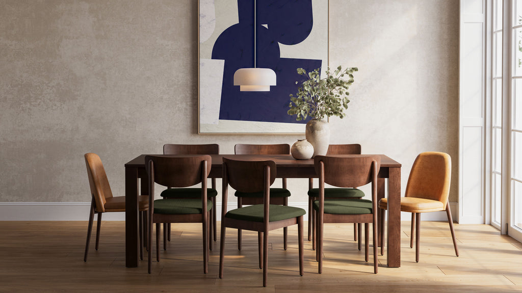 a dining room with a large painting on the wall and a wooden table with four chairs and a vase of flowers on the table