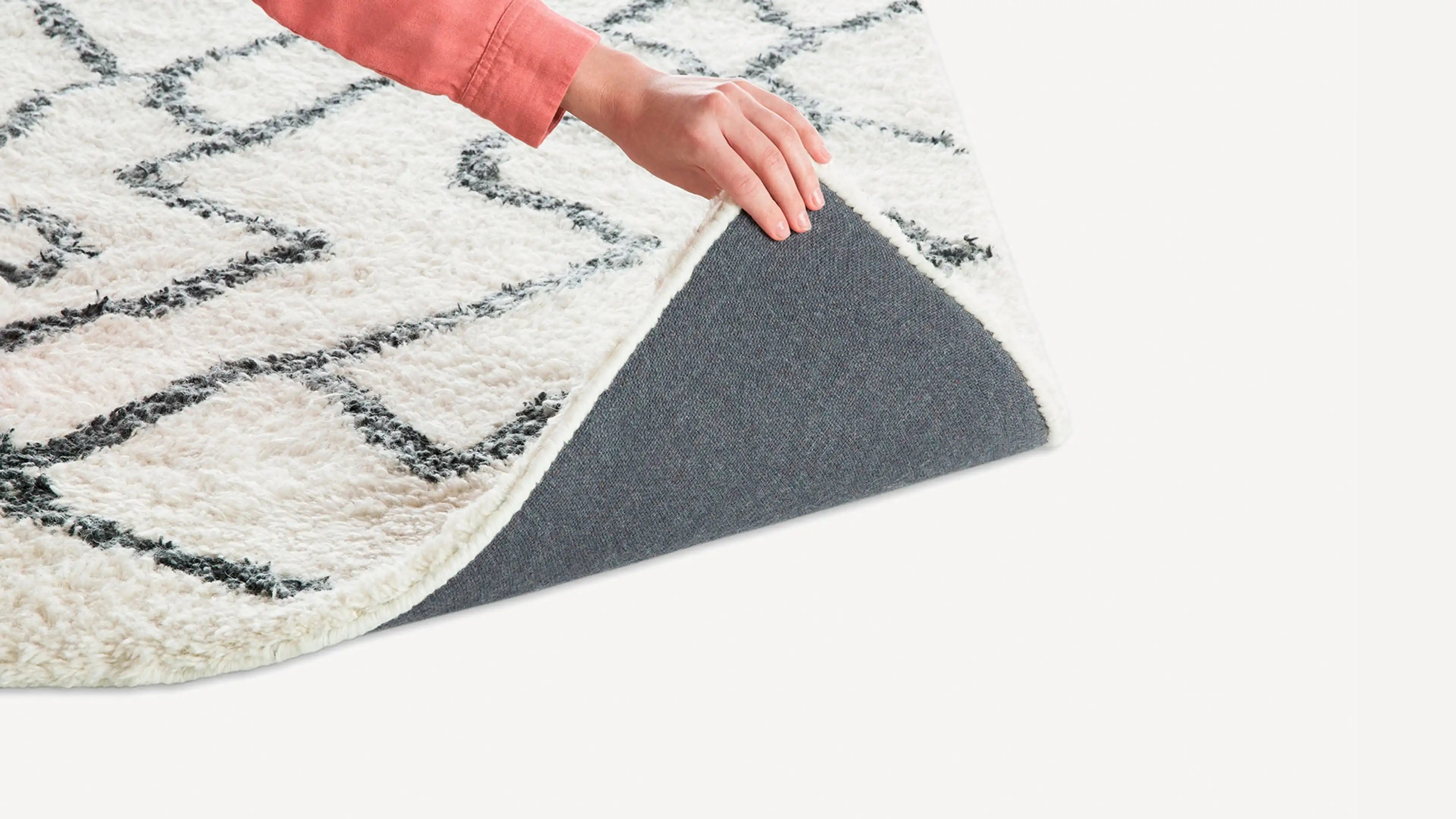 a woman is placing a rug on the floor