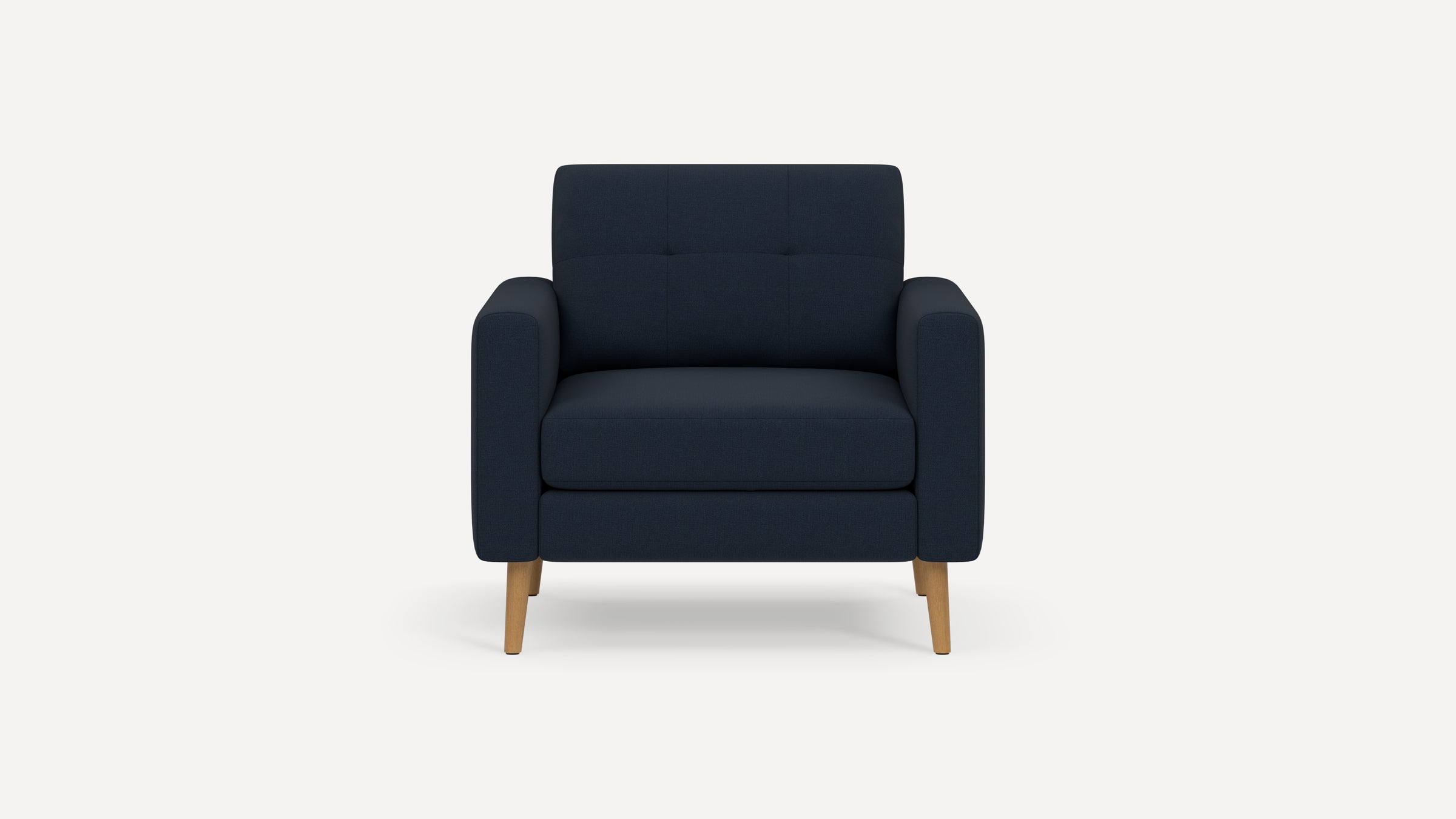 Modern dark navy upholstered armchair with wooden legs, square arms, and subtle button tufting on backrest.