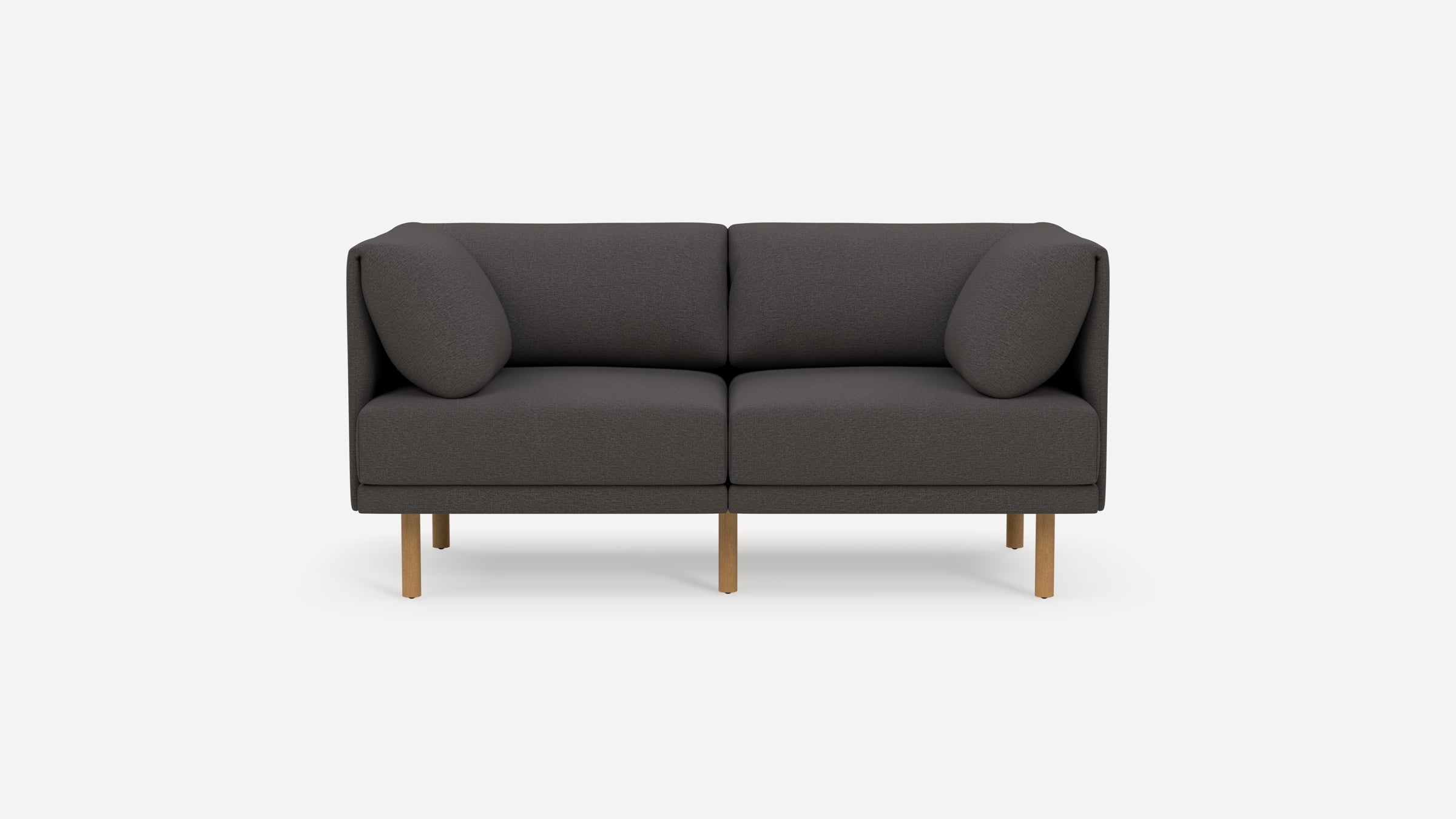 Modern dark gray two-seater sofa with rounded cushions and wooden legs, isolated on a plain white background.