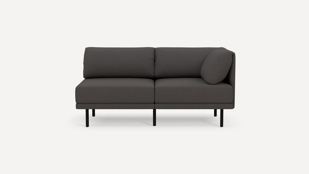 Modern dark gray fabric loveseat with clean lines, slim black metal legs, and a single round pillow on the right armrest.