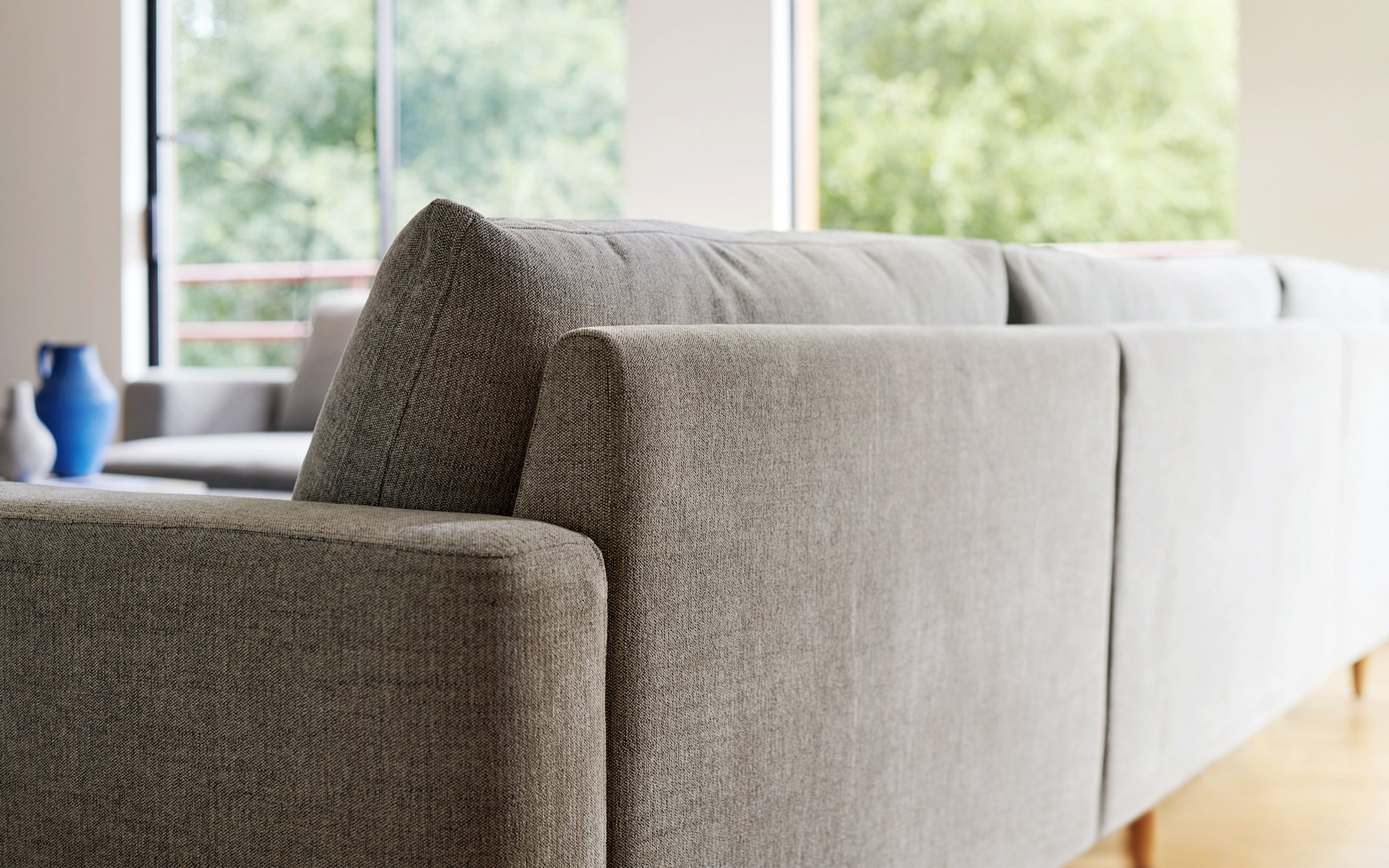 a modern living room with a large gray couch and wooden flooring