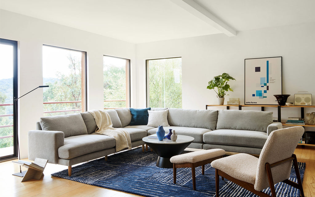 a modern living room with a large sectional sofa and matching ottomans