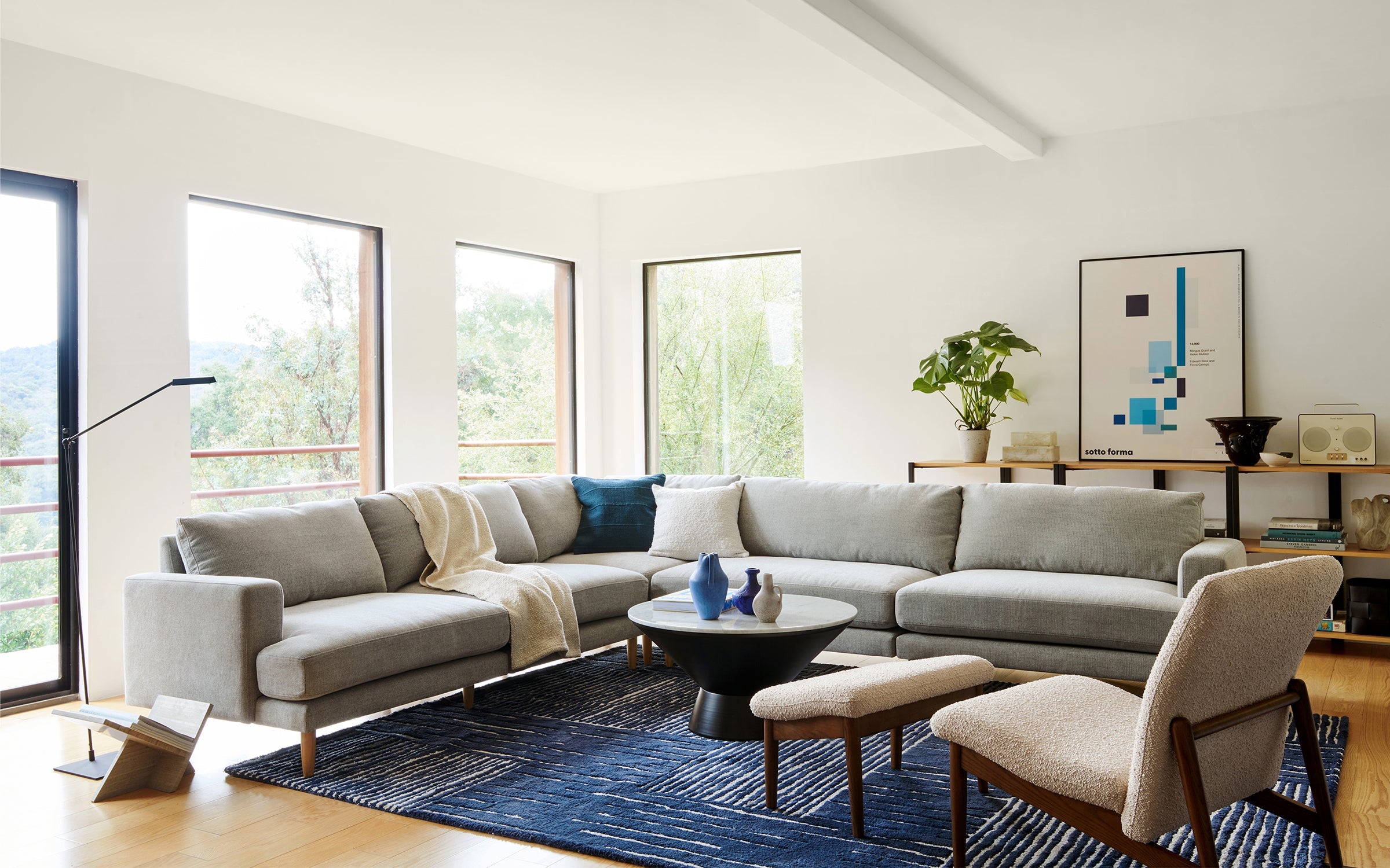 a modern living room with a large sectional sofa and matching ottomans