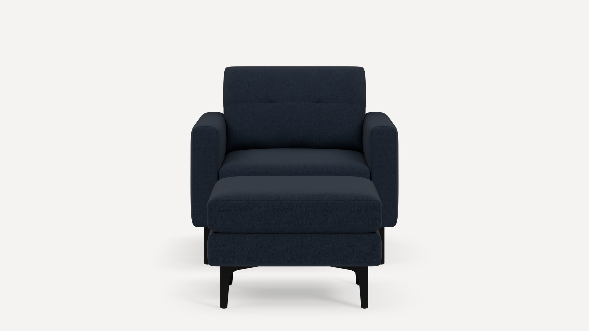 Front view of a modern navy blue armchair with a matching ottoman, featuring soft cushions and black legs, on a white background.
