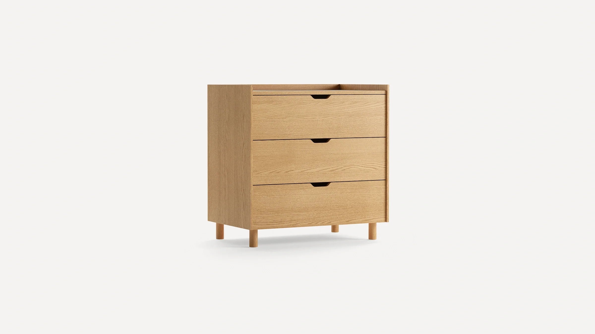 Light wood three-drawer chest with minimalist design, recessed handles, and four round legs.