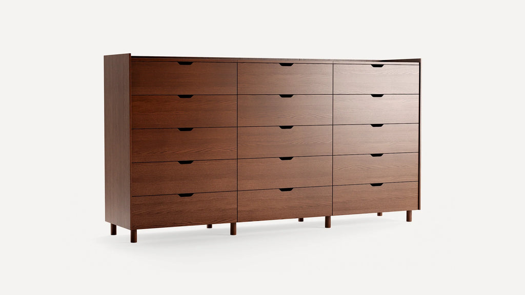 Large modern wooden dresser with sixteen spacious drawers, smooth finish, and minimalist recessed handles, standing on short cylindrical legs.