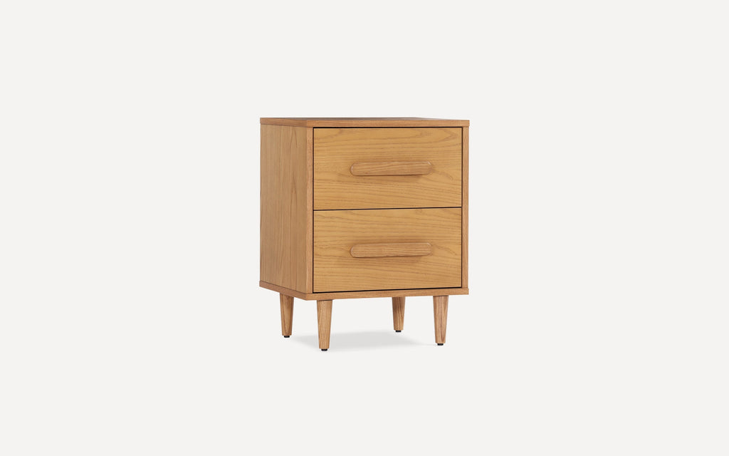 Mid-century modern two-drawer wooden nightstand with rounded handles and tapered legs in light oak finish.