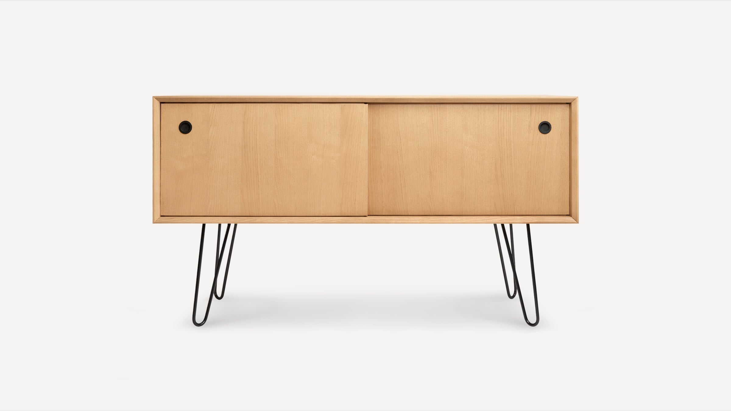 Light wood mid-century modern sideboard with sliding doors and black hairpin metal legs on white background.