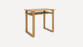 Modern light wood desk with flat top surface and an open shelf underneath, supported by geometric square legs.