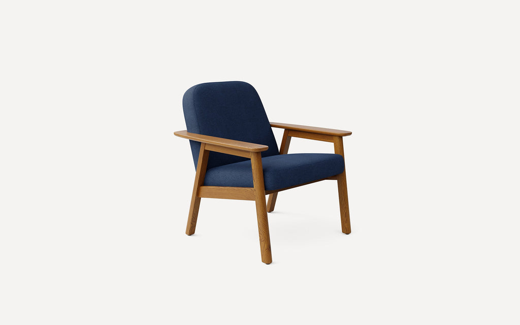 Mid-century modern armchair with blue upholstered seat and backrest, featuring light wooden frame and armrests.
