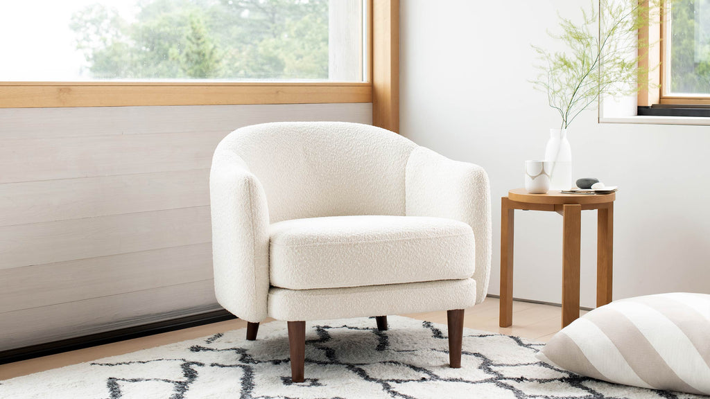 a modern living room with a white chair and a black and white rug