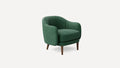 Modern green velvet armchair with rounded backrest and armrests, supported by four tapered wooden legs.